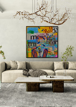 Ciao Bellas by María Burgaz in a black frame above a beige sofa under a branch chandelier