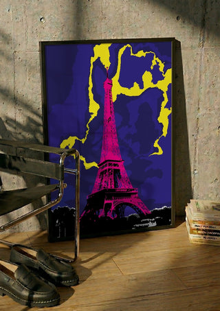The Tower by Massimo Frascogna in a black frame leaning against a concrete wall by a steel chair