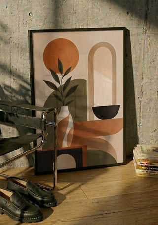 Abstract Earth-Tone Still Life by TimlessArtworks in a black frame leaning against a concrete wall by a steel chair