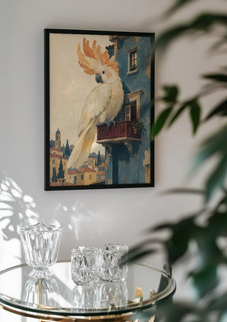 A Balcony of One’s Own by Matthews Gallerie in a black frame above a glass table with crystal glassware
