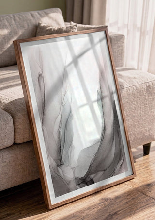 Traces of Wind by Anna Dormir in a walnut frame leaning against a grey sofa