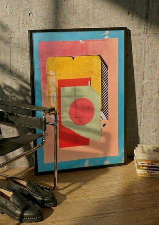 Vermilion Circle by Kareem Rizk in a black frame leaning against a concrete wall by a steel chair