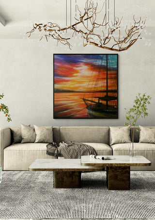 Sunset in red by Sunny in a black frame above a beige sofa under a branch chandelier