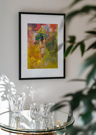 The weight of the world full colour by Madame Petit in a black frame above a glass table with crystal glassware