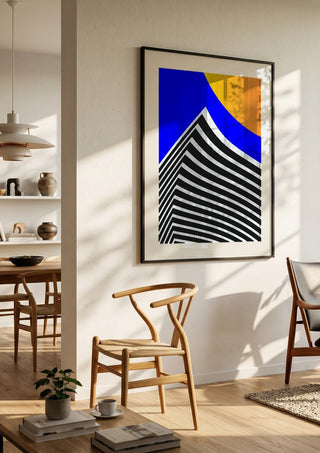 Pyramid by Aleksi Allan in a black frame in a bright dining room with wooden chairs