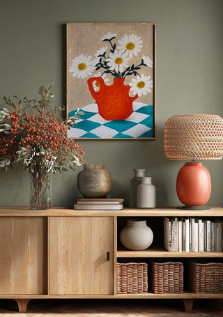 Vita blomster i röd vas by Rebecka Hansson above a wooden sideboard on a sage green wall