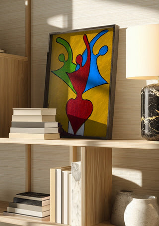 The Synthesis of Sel by Bibi in a dark frame on a wooden shelf beside books and a lamp
