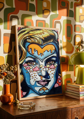 Marylin Monroe by Okiana in a wooden frame on a sideboard against retro patterned wallpaper