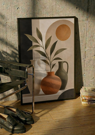 Terracotta Vase and Greenery by TimlessArtworks in a black frame leaning against a concrete wall by a steel chair