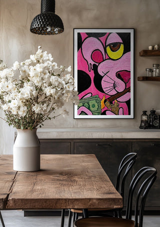 Capitalist Illusion by Bibi in a black frame above a rustic table with white flowers