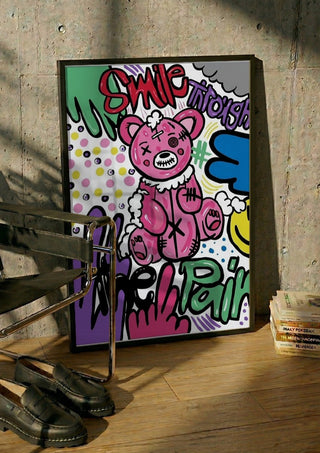 Smile Through The Pain by Bibi in a black frame leaning against a concrete wall by a steel chair