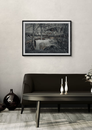 Decay by Lone Gjessing in a black frame above a dark sofa with white candlesticks