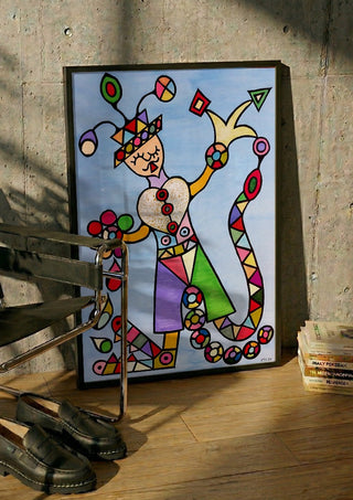 Figure with a Heart by Steffi Seiler in a black frame leaning against a concrete wall by a steel chair
