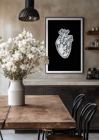 Still Beating by Nari in a black frame above a rustic table with white flowers