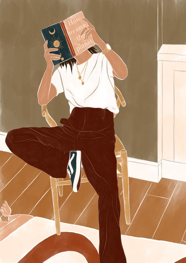 Person reading "How to Save the Planet" by Ivy Green while sitting on a chair in a cozy room.