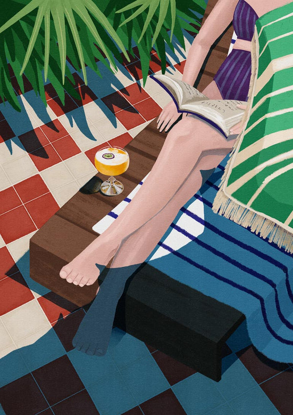 Woman reading on a lounge chair with a drink nearby, featured for Just one more chapter - Goed Blauw.