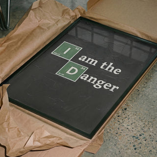 Framed "I am the Danger" Science Message print with periodic table elements, unboxed on brown wrapping paper.
