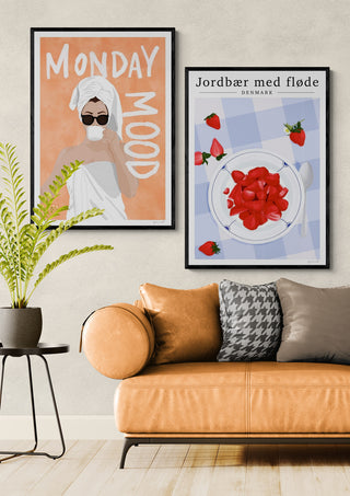 Framed "Monday Mood" poster by ByKammille displayed above a tan sofa in a modern living room.