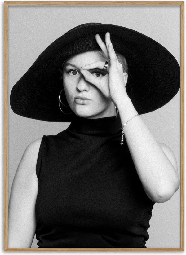 Back in time by Bettinafloorphoto - a black and white portrait of a woman in a wide-brimmed hat framing her eye with her hand