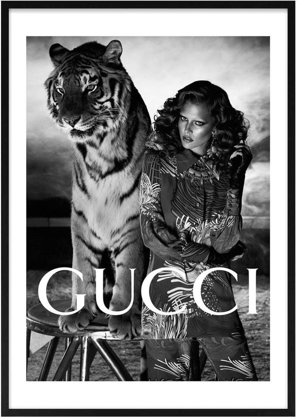 Black and white poster of a woman posing with a tiger, featuring GUCCI logo for the Tiger Fashion collection.